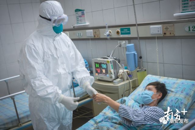 隔离病房内,患者拉着医生的手道谢。 南方日报记者 张梓望 李细华 摄
